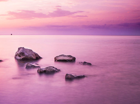 Beautiful seascape with rocks on the beach at sunset timeの写真素材