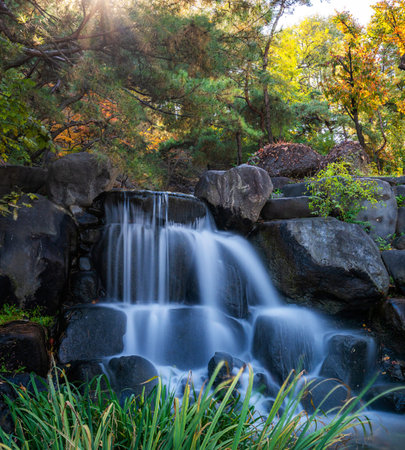 Beautiful waterfall in the autumn forest at sunset. Natural background.の写真素材