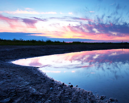 Sunset over a lake with a reflection in the water. Vivid colors.の写真素材