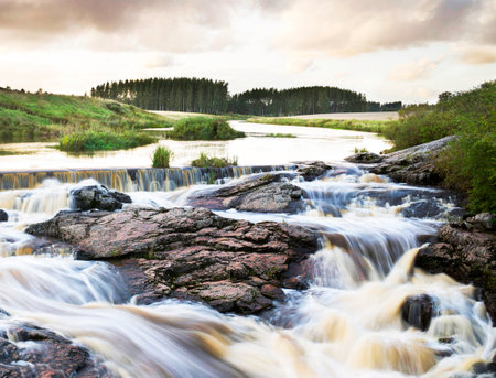 Long exposure of a waterfall on the river in the forest at sunsetの写真素材