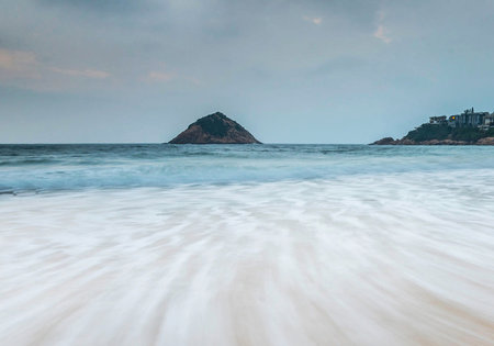 Beautiful seascape with sea waves and mountain in the backgroundの写真素材