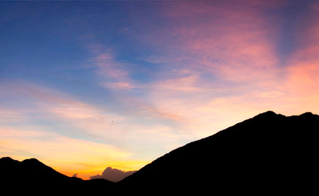 Sunset in the mountains, silhouettes of mountains and clouds.の写真素材