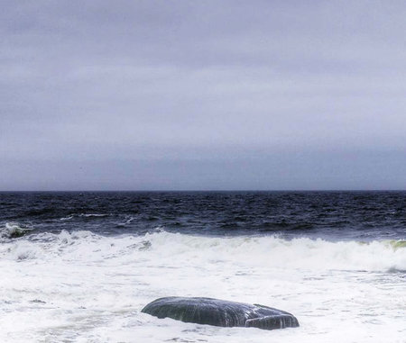 Seascape with a rock in the middle of the sea.の写真素材