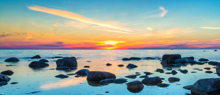 Beautiful sunset over the sea and rock in the foreground, panorama