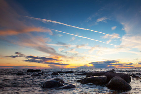 Sunset on the Baltic Sea with clouds in the sky and rocksの写真素材