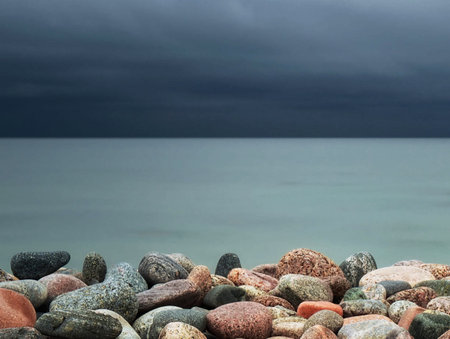 Pebbles on the seashore with stormy sky backgroundの写真素材