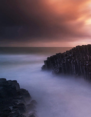 Long exposure shot of a stormy sea with a wooden breakwater.の写真素材
