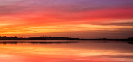 Beautiful sunset over the lake with reflection in the water. Panoramaの写真素材