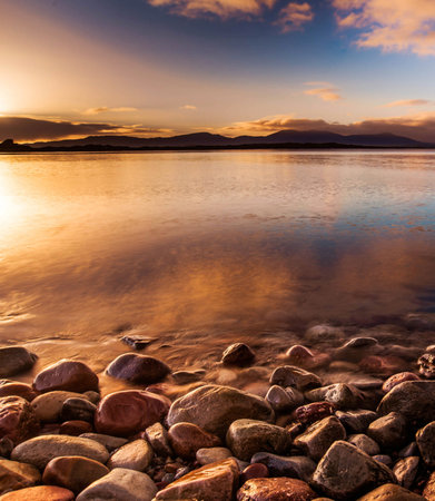 Sunset on the shore of the lake. Dramatic sky.の写真素材