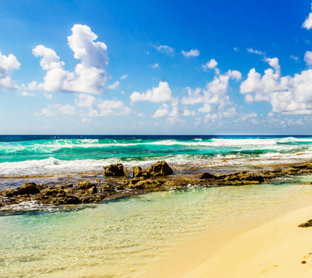 beautiful beach and tropical sea under the blue sky with white cloudsの写真素材