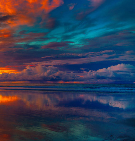 Beautiful sunset on the beach with clouds reflected in the water.の写真素材