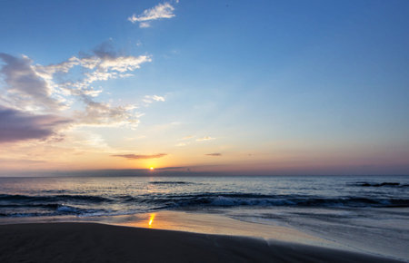 Beautiful sunset on the beach. The sun goes down over the sea.の写真素材