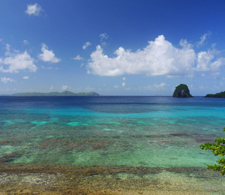tropical beach with white sand and turquoise water under blue skyの写真素材
