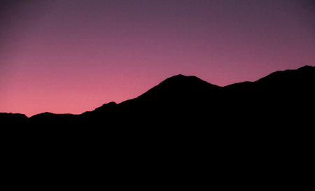 Silhouette of a mountain range in the evening at sunset.の写真素材
