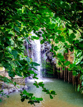 Tropical waterfall with green leaves in the rainforest of Bali, Indonesia