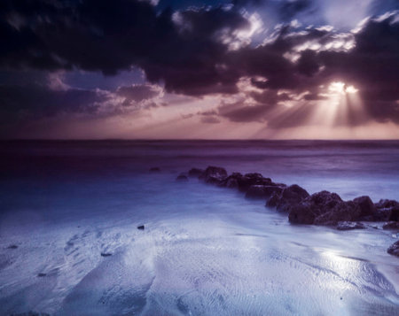 Beautiful seascape at sunset with clouds and rays of lightの写真素材