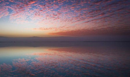 Sunset at the lake with clouds reflected in the water surface.の写真素材