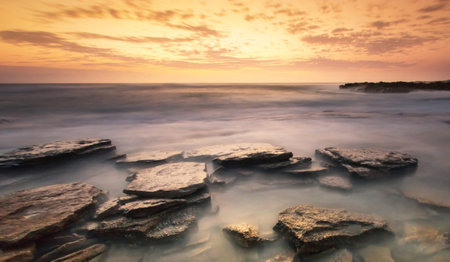Long exposure seascape with rocks at sunset. Long exposure shot.