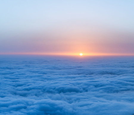 Sunrise above the clouds, view from the window of a plane