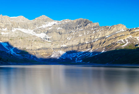 Mountain landscape with lake and snow-capped peaks in the background