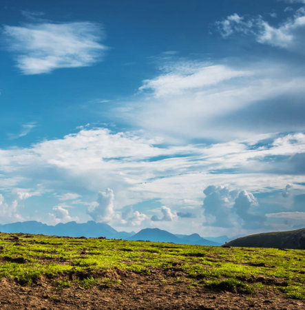 Beautiful mountain landscape with green grass and blue sky with clouds.の写真素材