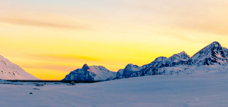 Panoramic view of snow-capped mountains at sunset in winterの写真素材