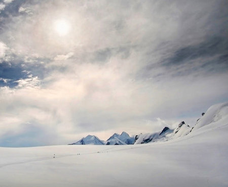 Beautiful winter landscape with snow covered mountains and blue sky with cloudsの写真素材