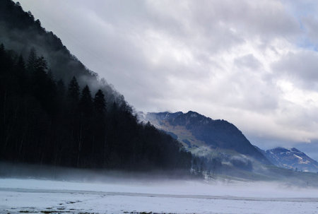 Foggy morning in the alps of Switzerland. Beautiful winter landscape.の写真素材