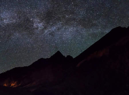 Milky Way over the mountain peak at night with stars and space dust