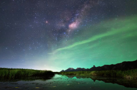 Milky Way over the lake. Aurora borealis in the sky.の写真素材