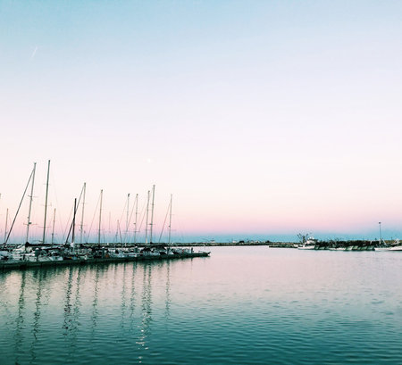 Yachts and boats moored in the harbor at sunset.の写真素材