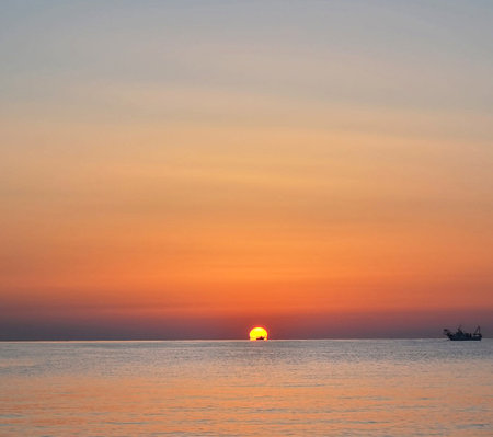 Beautiful sunset over the sea. Sunset over the sea. Beautiful sunset over the sea. The sun sets over the sea. The sun sets turning the sky yellow and orange.の写真素材