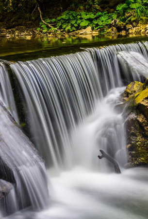 Beautiful small waterfall in the forest, long exposure shot, long exposure