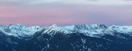 panoramic view of snowy mountains in the evening with pink sky