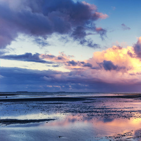 Sunset over the sea with clouds reflected in the water. Beautiful seascape.の写真素材