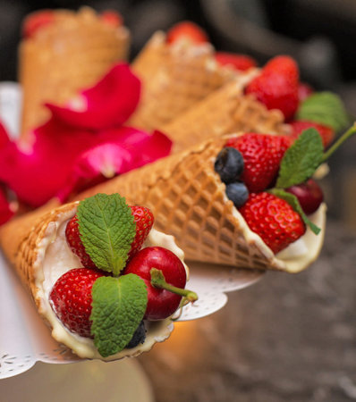 Ice cream cones with berries and mint on a table in a restaurantの写真素材