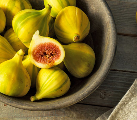 Fresh figs in a bowl on a wooden background. Selective focus.の写真素材
