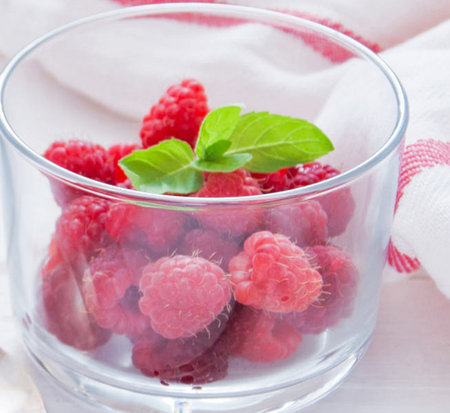 Raspberries and mint in a glass on a white background.の写真素材