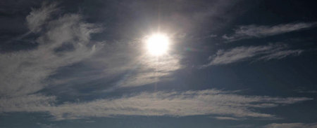 Panorama of blue sky with white clouds and sun in the backgroundの写真素材