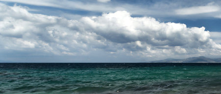Panoramic view of the sea and blue sky with white cloudsの写真素材