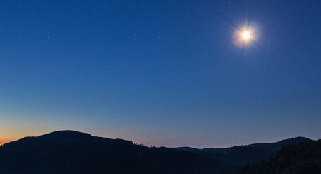 Moon and stars in the night sky over the mountains. Panoramaの写真素材