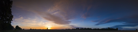 Warm sunset and dramatic cirrus clouds over rural idyll. Perspective corrected stitched panorama, detailed when viewed large.の写真素材