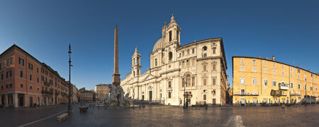 Fountain of the Four Rivers (1651) overlooked by the church of Sant'Agnese in Agone in the beautifully Baroque Piazza Navona (1651) illuminated by warm early morning sunlight.の写真素材