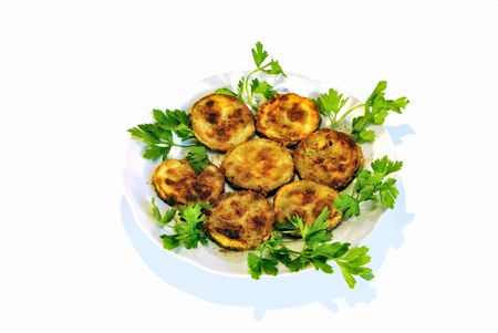 A dish of fried vegetable marrow with fresh parsley at the white plateの写真素材