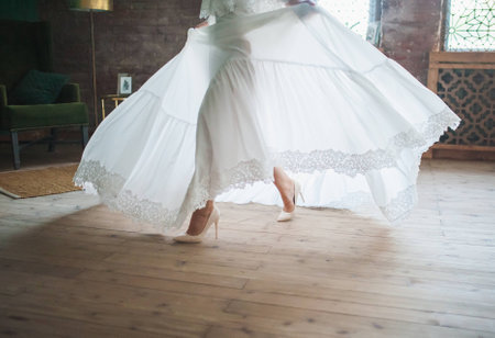 Legs of a girl in a white dress that goes fastの写真素材