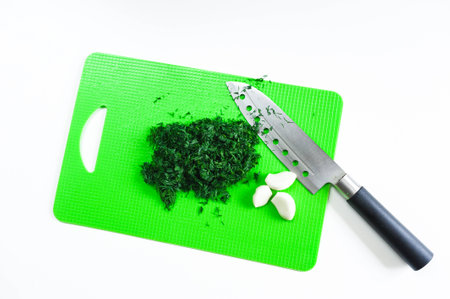 Dill, parsley, green onions lie on the kitchen cutting boardの写真素材