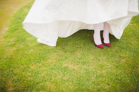 Red/crimson shoes with high heels on bride's feetの写真素材