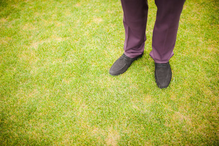 Black Sneakers shoes walking on green grass with copy space.の写真素材