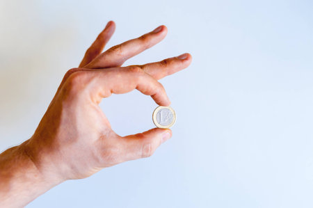 Euro cent coin in man hand on white background