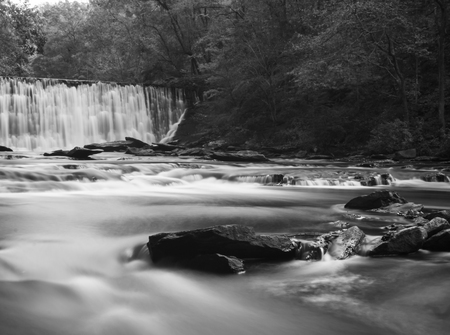 soft slow moving creek below a dam shot with long exposureの写真素材